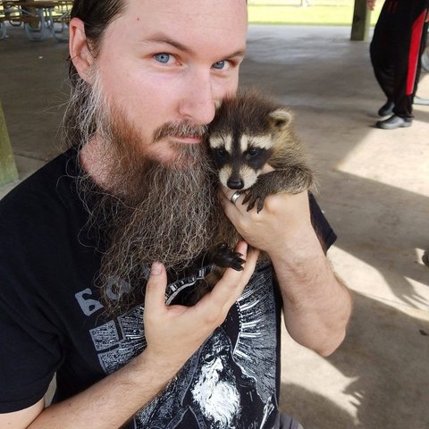 Nick Goodyear holding a baby raccoon